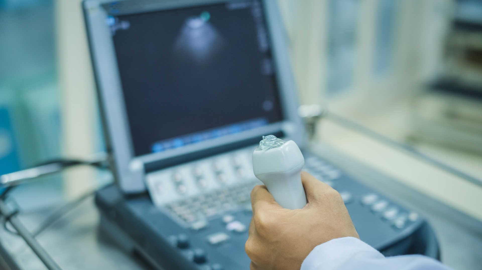 Doctor holding an echo probe in front of an echo machine